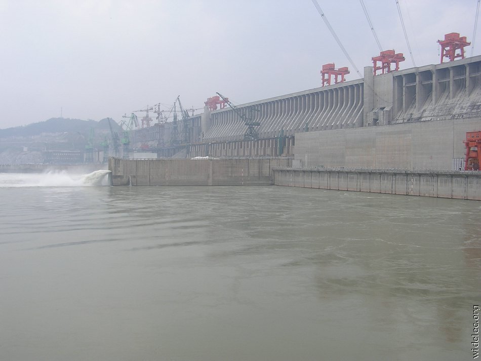 Люди перегородили реку большой плотиной вода. Санься ГЭС. Три ущелья ГЭС. Асуанский гидроузел. Плотина 3 ущелья.